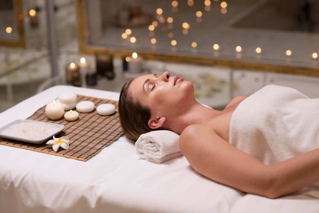 Woman receiving spa services including a full body massage in a calming environment